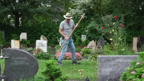 Friedhofswärter Willi Möck auf dem Friedhof in Ofterdingen beim rechen