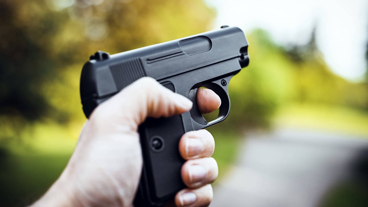 Jemand hält eine Waffe (Symbolfoto). Die Waffen, mit denen die Kinder in Reutlingen einen Polizeieinsatz ausgelöst haben, waren laut Polizei nicht echt.