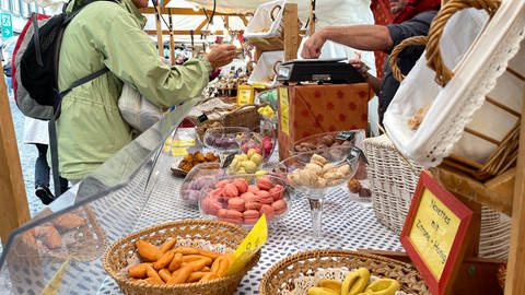 Beim umbrisch-provenzalischen Markt in Tübingen dürfen auch die bunten französischen Macarons nicht fehlen. Für viele Gäste gehören sie zu den Hinguckern. An einem Stand mit Macarons verkauft ein Händler gerade einige der süßen Kleinigkeiten.