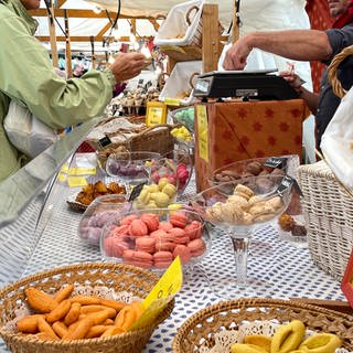 Beim umbrisch-provenzalischen Markt in Tübingen dürfen auch die bunten französischen Macarons nicht fehlen. Für viele Gäste gehören sie zu den Hinguckern. An einem Stand mit Macarons verkauft ein Händler gerade einige der süßen Kleinigkeiten.