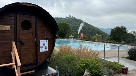 Im Freibad in Bad Urach steht eine mobile Sauna neben dem Schwimmbecken.