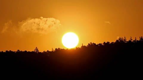 Kurz nach dem Sonnenaufgang leuchtet der Himmel über dem Neckartal bei Weilheim in intensivem Orange.