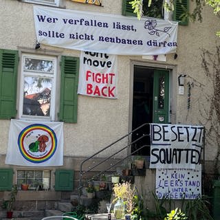 An der Außenfassade des besetzten Hauses in Tübingen hängen Transparente 