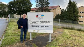 Hermann Fritz neben einem Empfangsschild vor dem Ankunftszentrum Ukraine in Meßstetten. Fritz hat sich ehrenamtlich für geflüchtete Ukrainer engagiert.