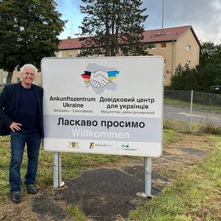 Hermann Fritz neben einem Empfangsschild vor dem Ankunftszentrum Ukraine in Meßstetten. Fritz hat sich ehrenamtlich für geflüchtete Ukrainer engagiert.