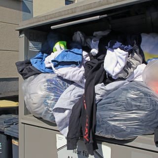 Ein überfüllter Container mit Altkleidern. Das DRK im Zollernalbkreis befürchtet, auf den vielen alten Klamotten sitzen zu bleiben (Symbolbild)