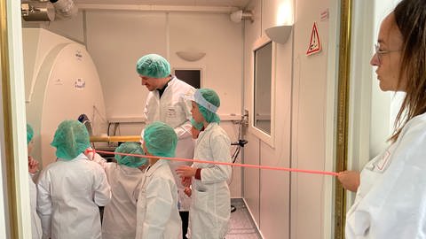 Kinder in Laborkitteln stehen vor einem MRT-Gerät und lassen sich von Forschern erklären, wie das geht. Die Uniklinik Tübingen hatte zum Aktionstag "Türen auf mit der Maus" eingeladen.