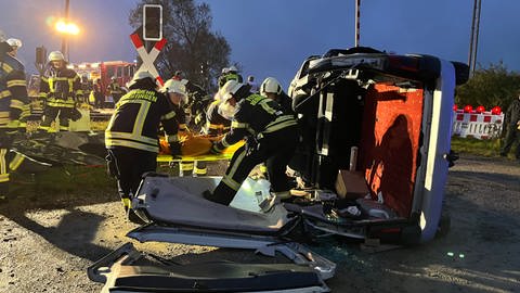 Feuerwehrleute befreien bewusstlose Menschen aus Auto nach schwerem Unfall. Den Ernstfall nach Zugunglück haben am Donnerstagabend über 200 Rettungskräfte zwischen Herbertingen und Mengen im Kreis Sigmaringen geübt.