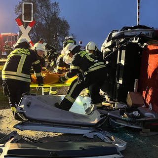 Feuerwehrleute befreien bewusstlose Menschen aus Auto nach schwerem Unfall. Den Ernstfall nach Zugunglück haben am Donnerstagabend über 200 Rettungskräfte zwischen Herbertingen und Mengen im Kreis Sigmaringen geübt.