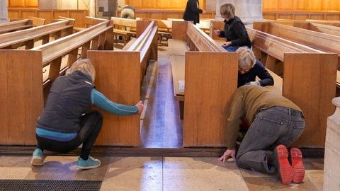 Harte Fitzelarbeit - die Kirchenbänke müssen zunächst vom Holzboden abgeschraubt werden.