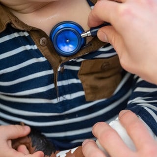 Ein Kinderarzt untersucht ein Kind mit einem Stethoskop. Für Eltern in Horb am Neckar und der Umgebung könnte es bald schwierig werden, einen Kinderarzt für ihre Kinder zu finden. 