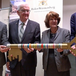 Ministerpräsident Winfried Kretschmann übergibt symbolisch einen Schlüssel bei der Einweihung des neuen Gebäudes des Islamischen Instituts in Tübingen. Daneben Prorektor Samuel Wagner und Gisela Splett, Staatssekretärin im Ministerium für Finanzen.  