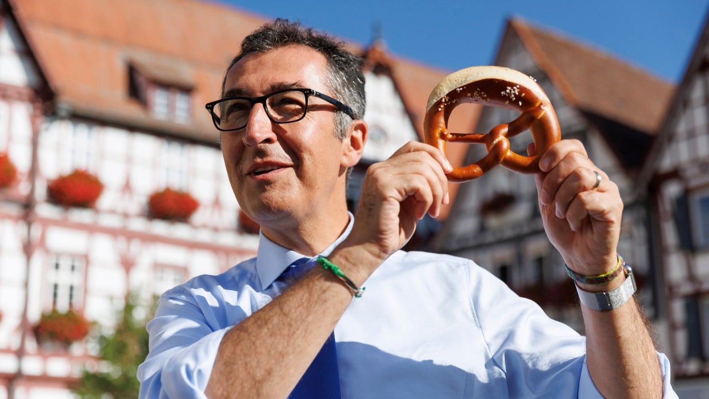 Cem Özdemir, Bündnis 90/Die Grünen, Bundesminister für Ernährung und Landwirtschaft, steht auf dem Marktplatz in Bad Urach und hält eine Brezel in den Händen. Er wird Ehrenbürger der Stadt.