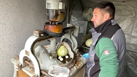 Der Enkel von Josef Hugger steht and der Maschine und hobelt das Filderkraut.