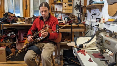 Stefan Schwarz, der Mitarbeiter von Andreas Rogge, spielt den irischen Dudelsack in der Werkstatt in Rottenburg-Wendelsheim im Kreis Tübingen.