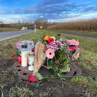 Menschen legen Blumen an der Stelle ab, an der der 14-jährige Radfahrer in Gomaringen (Kreis Tübingen) ums Leben kam.