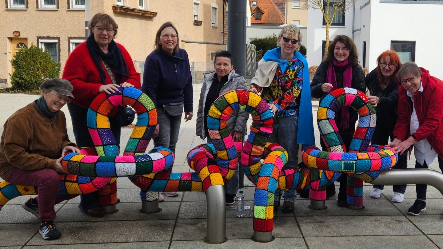 Die vielen Helferinnen präsentieren ihre mit Häkelkunst eingepackte Skulptur