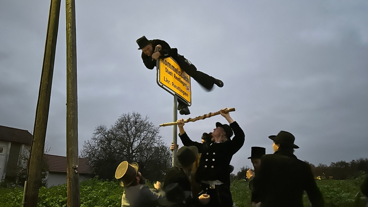 Letzte Hürde vorm Nachhausekommen: Nach sechs Jahren auf der Walz muss Zimmermann Felix Hennig über das Ortsschild von Rommelsbach klettern.