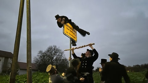 Letzte Hürde vorm Nachhausekommen: Nach sechs Jahren auf der Walz muss Zimmermann Felix Hennig über das Ortsschild von Rommelsbach klettern. 