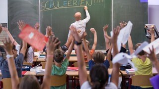 Lehrerschreibt an die Tafel Schulferien