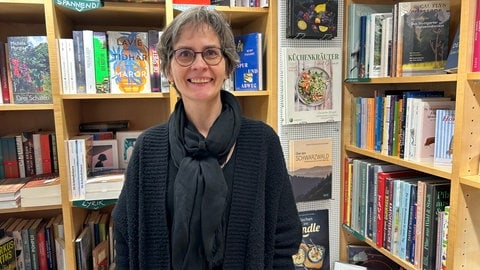 Helge Noack steht vor einem Bücherregal. Sie hat einen Buchladen in Tübingen. Woher die "Sitzende" ihre Blumen hat, weiß sie nicht. Aber sie hat eine Vermutung.