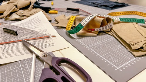 Schere, Maßband, Schneidematten, Geodreieck liegen auf dem Tisch im Seminarraum. Alte Textilien kann in Reutlingen im Textil-Recycling-Café der Bruderhaus-Diakonie unter Anleitung zu Neuem umnähen. 