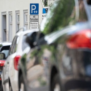 Ein Schild weist in der Innenstadt auf ein Parkgebiet für Bewohner hin und steht vor parkenden Autos. In Tübingen müssen Anwohner ab Dezember mehr Parkgebühren zahlen.