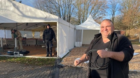 Andi Wachendorfer verlegt Kabel. Er ist zuständig für die Videowände, auf die die Bischofsweihe in Rottenbrug live übertragen wird.