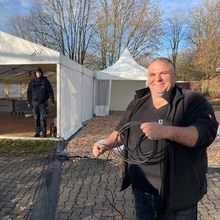 Andi Wachendorfer verlegt Kabel. Er ist zuständig für die Videowände, auf die die Bischofsweihe in Rottenbrug live übertragen wird.