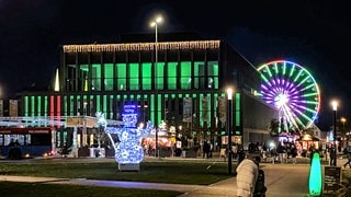 Nächtlich beleuchteter Weihnachtsmarkt mit Riesenrad um die Stadthalle in Reutlingen. Die Betreiber kämpfen mit stark erhöhten GEMA-Gebühren.