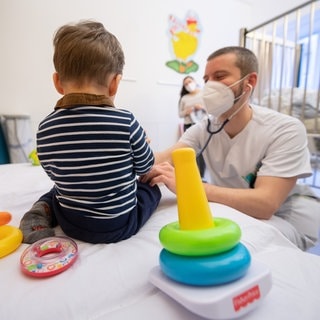 Ein Arzt untersucht in einer Kinderklinik ein Kind. Mehrere Kommunen im Kreis Freudenstadt suchen mit einer krativen Anzeige im Internet Kinderärzte.