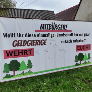 Ein Plakat in Starzach gegen den Windpark: "Wehrt euch." Verliert die Gemeinde die Idylle oder sind die Windräder eine Chance?