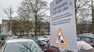 Ein Schild weist darauf hin, dass der Parkplatz an der Uni Tübingen bald Gebühren kosten wird. Damit ist der legendäre Schiebeparkplatz bald Geschichte.