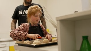 Die siebenjährige Malou bereitet Vollkornbrötchen in einem Kurs für gesunde Ernährung zu. 