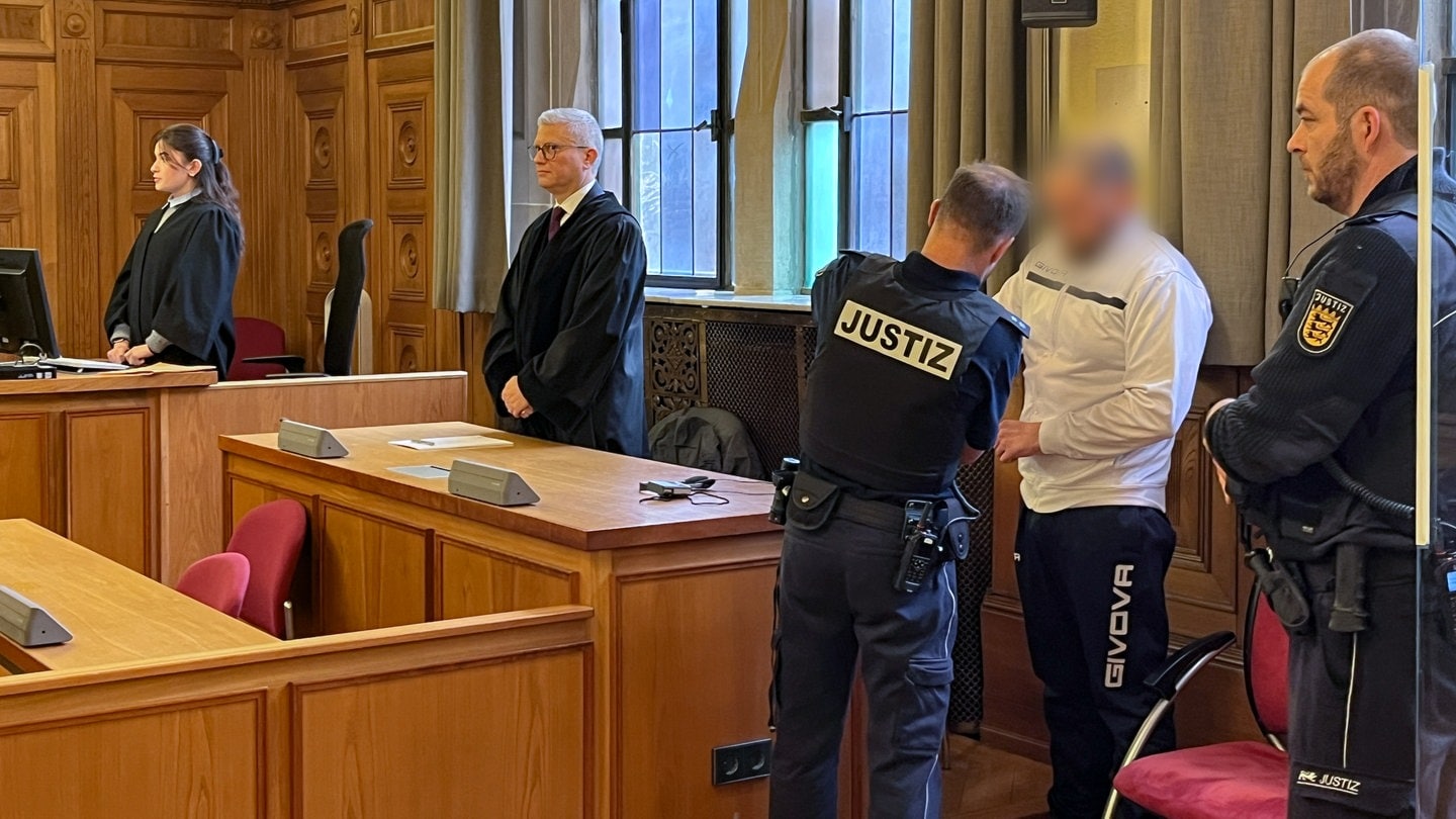 Ein Mann steht als Angeklagter im Landgericht Tübingen neben einem Justizbeamten. Er wurde verurteilt, seine Ehefrau in Bad Liebenzell getötet zu haben.