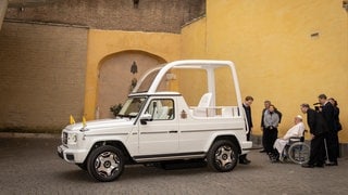 Papst Franziskus sitzt im Rollstuhl vor dem neuen Papamobil im Vatikan - der Spezialhersteller Paravan aus Aichelau hat es barrierefrei aufgerüstet.