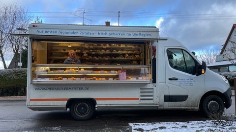 Gabi Link im Bäckermobil der Familie Link vor dem Haus einer Kundin.