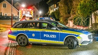 Polizeiwagen stehen am Abend in Stadtteil Ihlingen bei Horb am Neckar und sperren eine Straße.