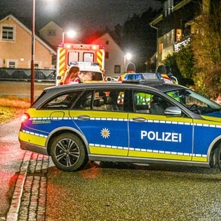 Polizeiwagen stehen am Abend in Stadtteil Ihlingen bei Horb am Neckar und sperren eine Straße.