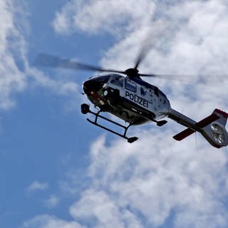 Polizeihubschrauber von unten vor blauem Himmel (Symbolbild)