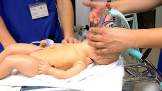 Eine Baby-Puppe liegt auf einem speziellen Früchchen-Tisch. Frühgeborene Kinder brauchen oft Sauerstoff, weil sie noch nicht selbständig atmen.