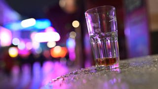 Ein fast leeres Glas auf einem Tisch: Alkohol gehört für viele zur Fasnet oder zum Fasching dazu. Was gegen Kater wirklich hilft