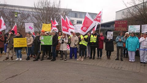 Die Gewerkschaft ver.di hat für Dienstag (28.2.23) zu Warnstreiks in den Alb-Donau-Kliniken aufgerufen. Mitarbeitende der Klinik in Ehingen haben sich vor dem Gebäude mit ihren Plakaten versammelt.