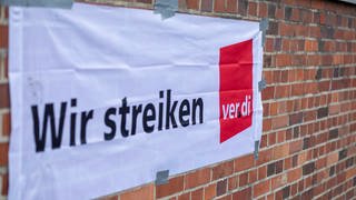 Banner mit rotem ver.di-Logo und den Worten "Wir streiken. Die Gewerkschaft ver.di hat Kliniken im Ostalbkreis zum Warnstreik aufgerufen. 