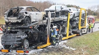 Ein in Brand geratener Fahrzeugtransporter am Straßenrand. Auf der A7 bei Altenstadt (Kreis Neu-Ulm) ist am Freitagmorgen ein mit mehreren Pkw beladener Autotransporter in Brand geraten.