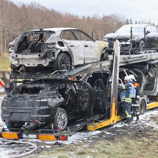 Ein in Brand geratener Fahrzeugtransporter am Straßenrand. Auf der A7 bei Altenstadt (Kreis Neu-Ulm) ist am Freitagmorgen ein mit mehreren Pkw beladener Autotransporter in Brand geraten.