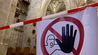 Ein Warnschild weist Besucher darauf hin, dass bestimte Bereiche im Ulmer Münster gesperrt sind. Denn in der Kirche bröckelt Putz von der Decke. 