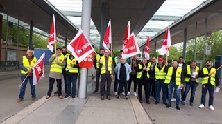 Busfahrer in gelben Warnwesten und mit rot-weißen ver.di-Fahnen am Bussteig am Zentralen Omnibushalt in Heidenheim. Sie streiken für mehr Geld und ein besseres Angebot der Arbeitgeber in der vierten Verhandlungsrunde.