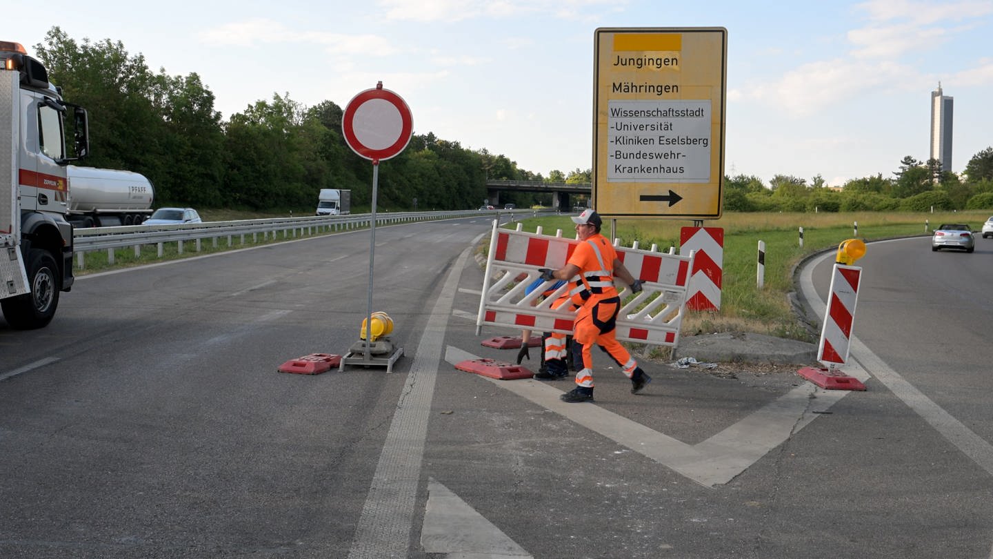 Ein Mann räumt die B10 bei Ulm, die drei Wochen lang gesperrt war, wieder für den Verkehr frei.