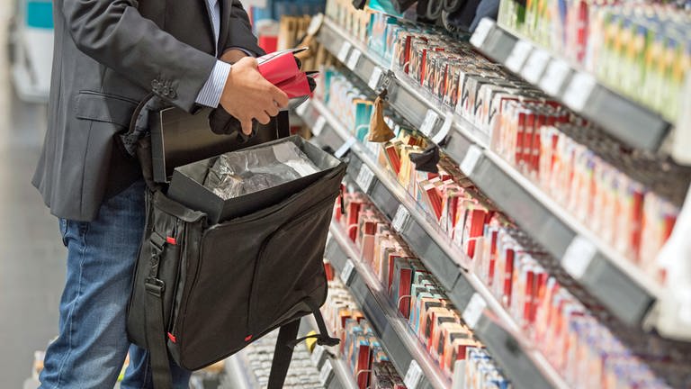 Ein Mann steckt Ware in seine Tasche: Ladendiebstahl im Supermarkt, Discounter und Baumarkt hat wieder stark zugenommen.